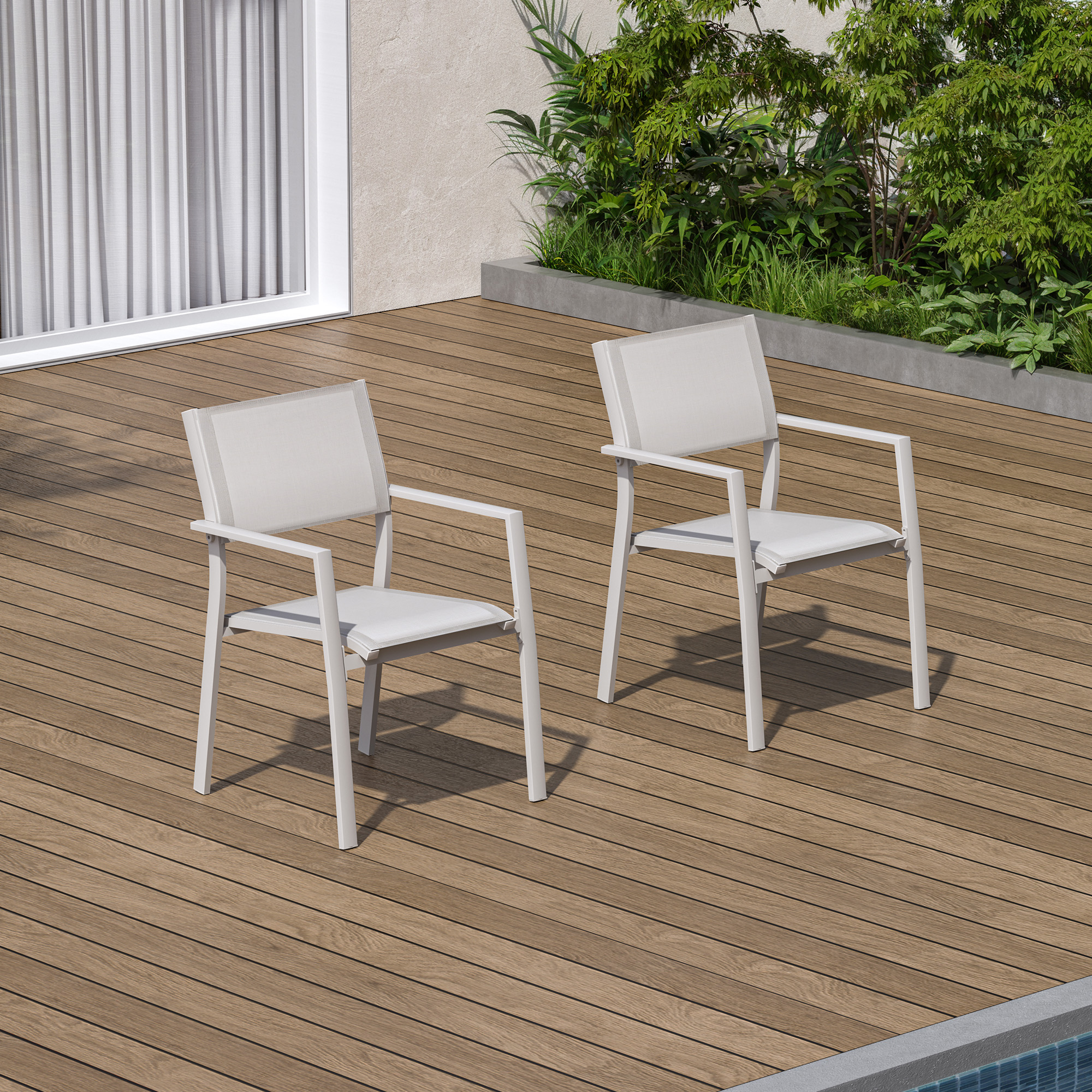 Two white stackable patio dining chairs with textile seats on wooden deck near pool-Seehill