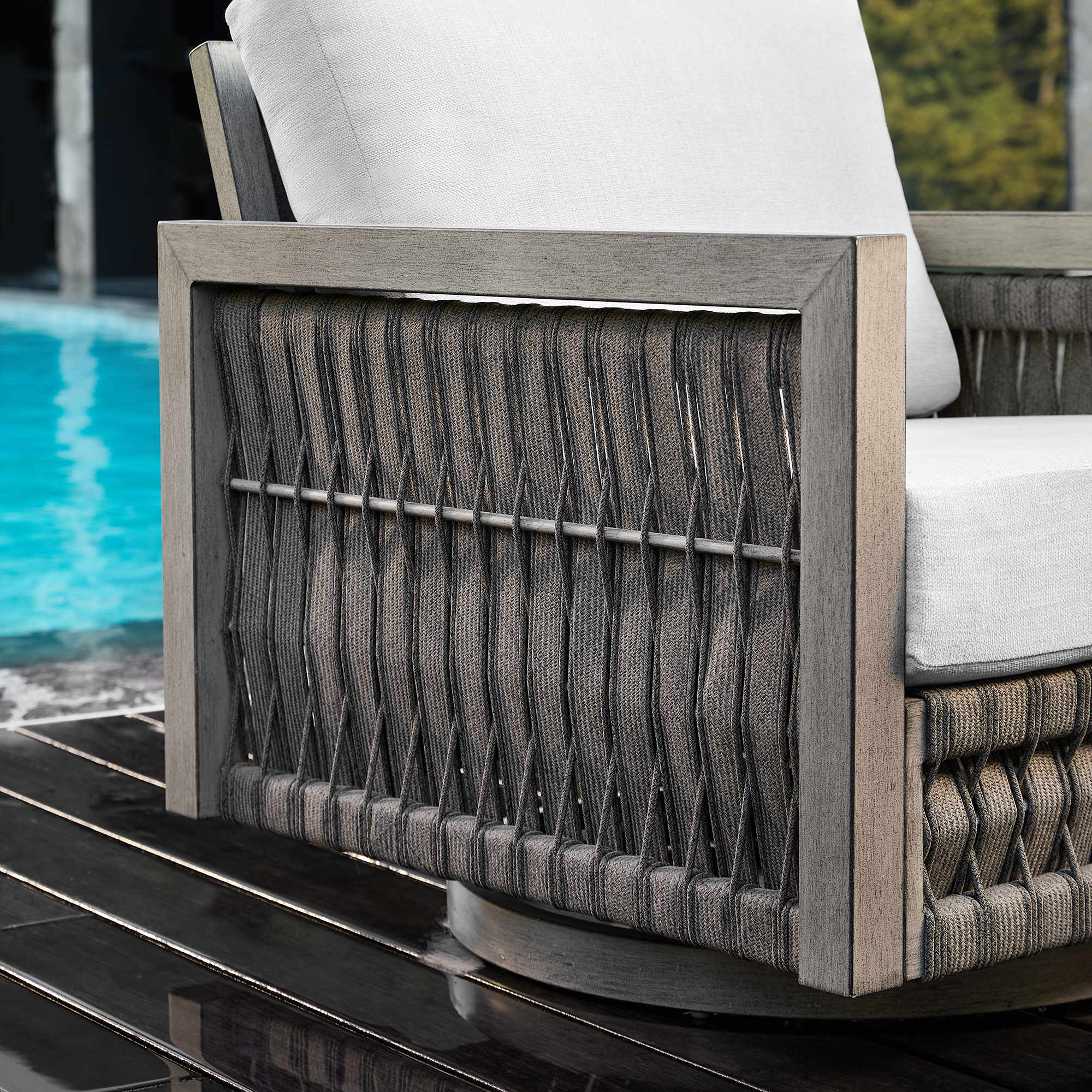 Crafted with a modern outdoor armchair with woven texture and white cushion near the pool, this oversize sofa offers exceptional relaxation. - Seehill