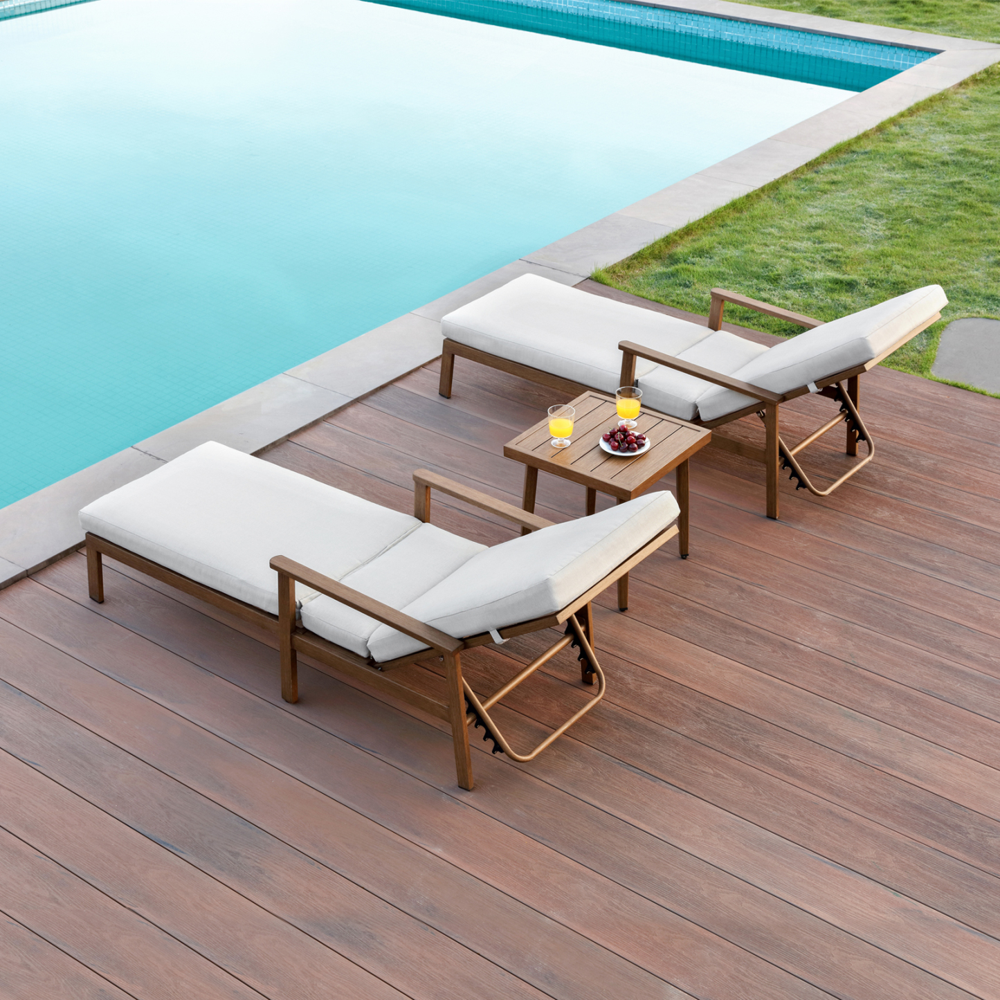 Outdoor wooden lounge chairs with white cushions near pool - Seehill