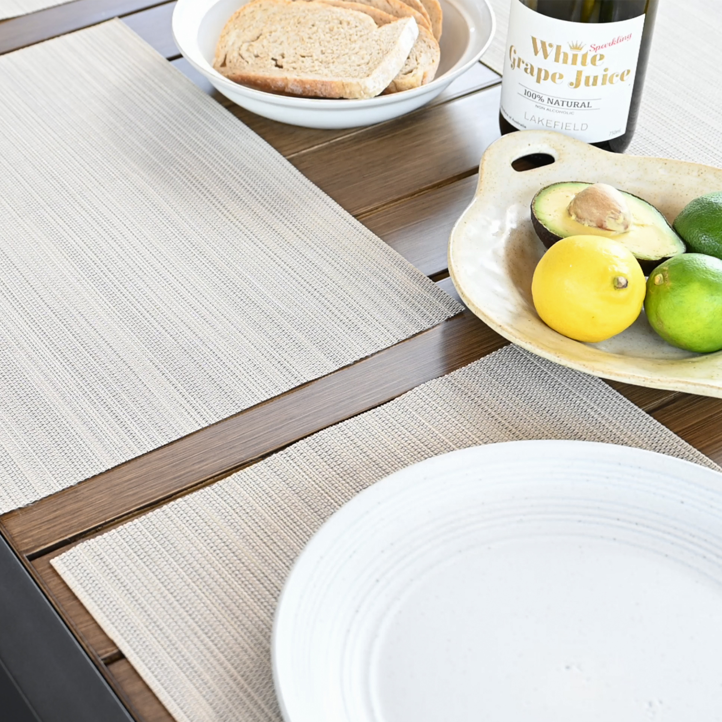 Explore the set of clean, beige placemats with a subtle textured weave on a wooden table, offering versatility. - Seehill