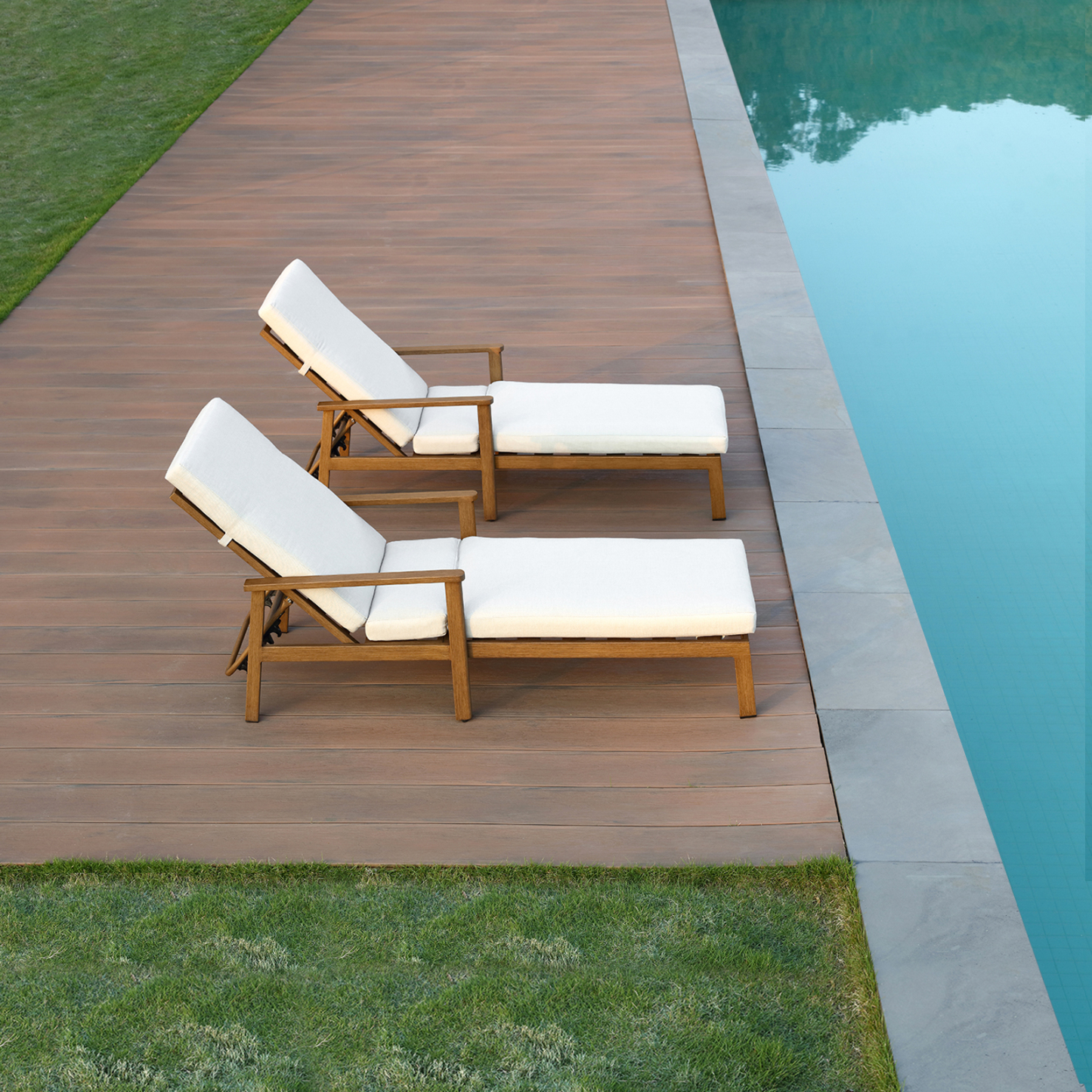 Wooden outdoor lounge chairs with white cushions by pool - Seehill