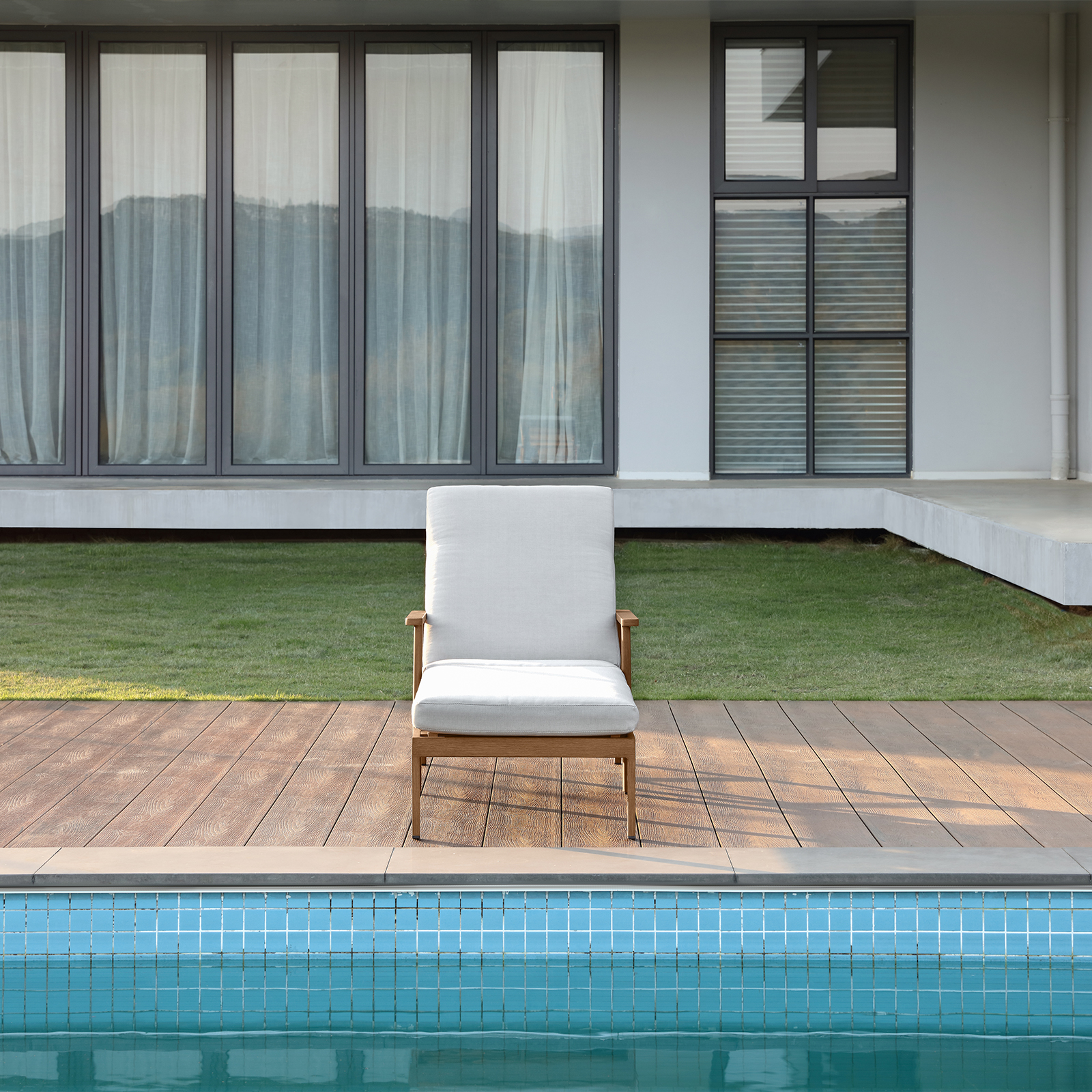 Modern outdoor lounge chair with white cushion near pool - Seehill