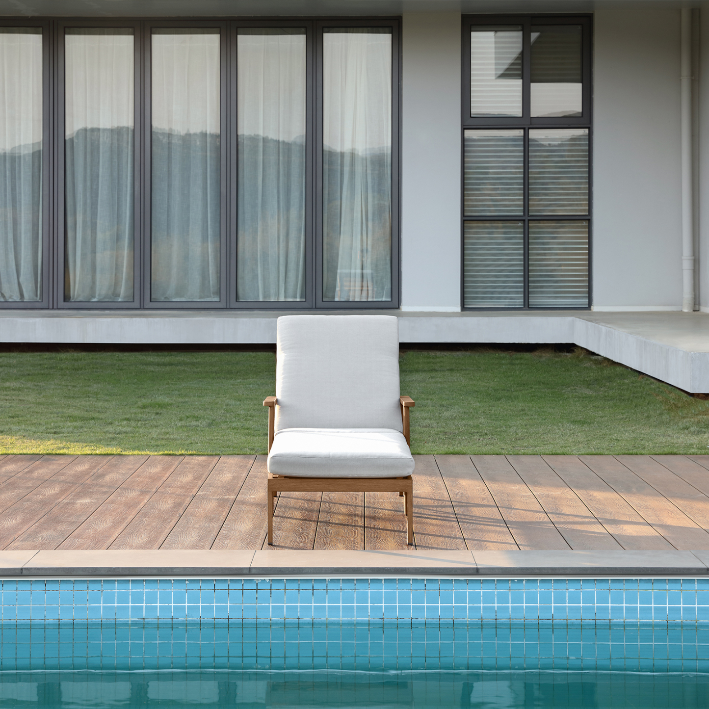 Modern outdoor lounge chair with white cushion near pool - Seehill
