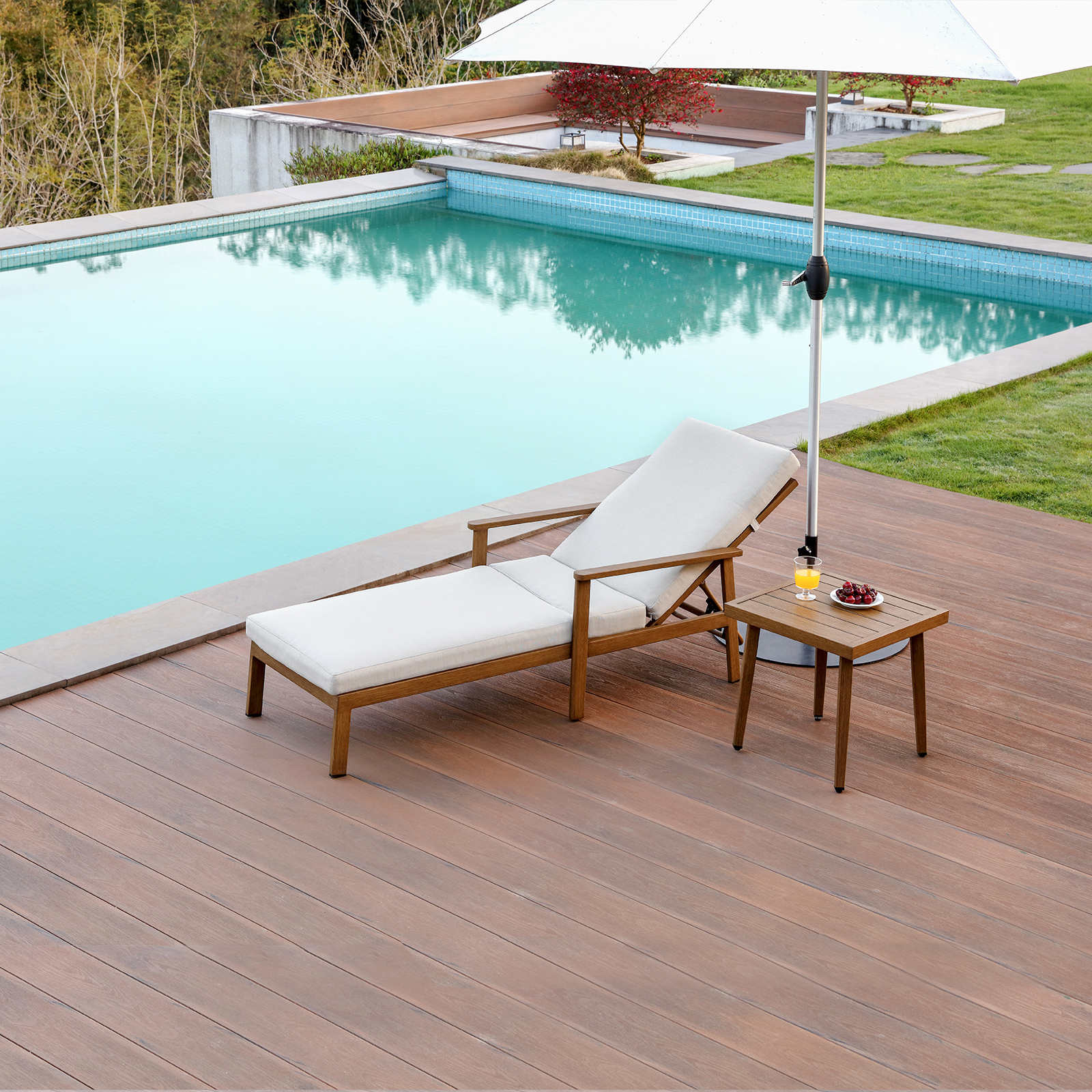 Teak lounge chair with cream cushion and side table by pool - Seehill