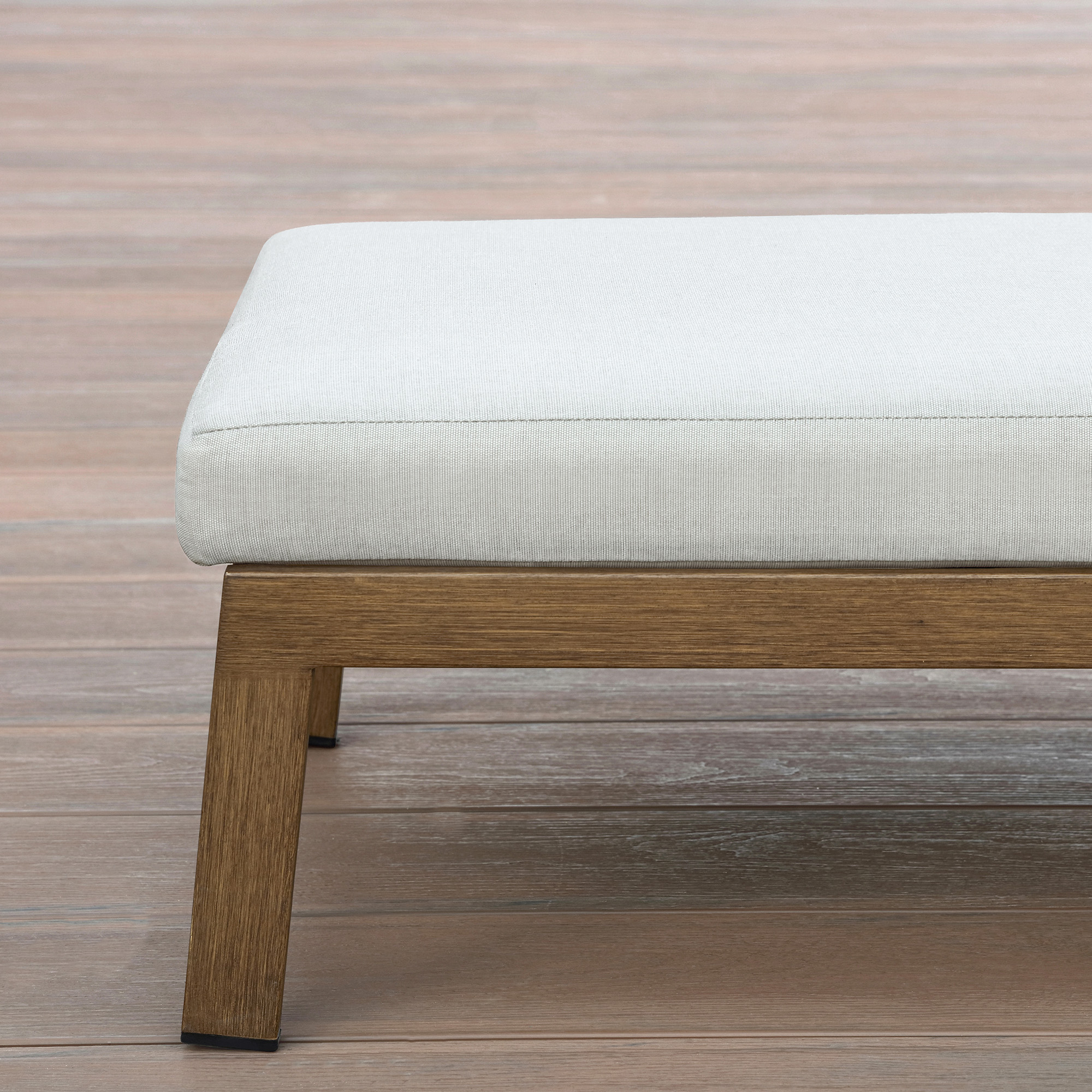 Close-up of outdoor lounge chair with thick white cushion and wooden frame on deck-Seehill