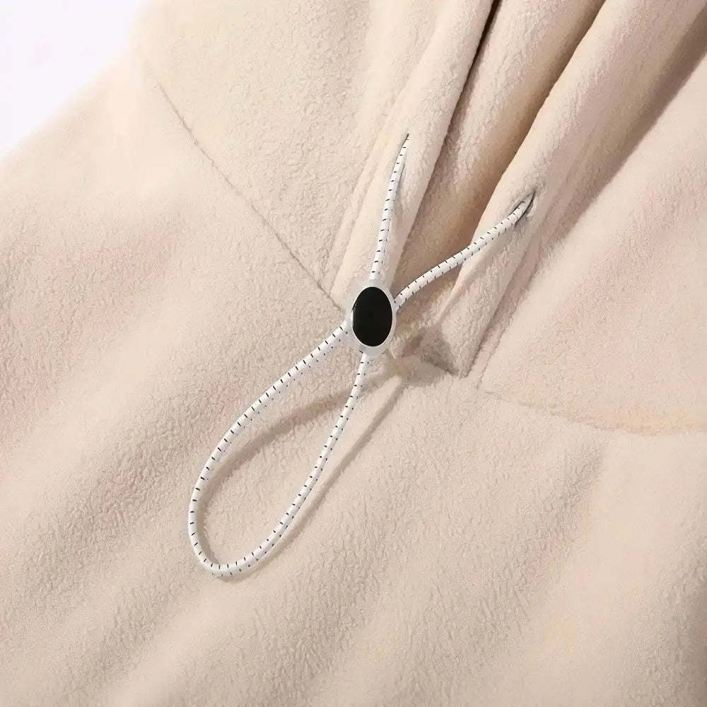 Close-up of a black button on a beige fabric background