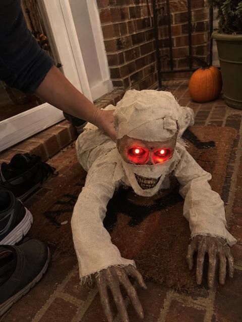 Crawling mummy being positioned on a brick front porch