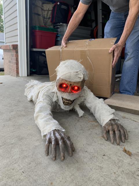 Homeowner taking the crawling mummy out near a garage storage box