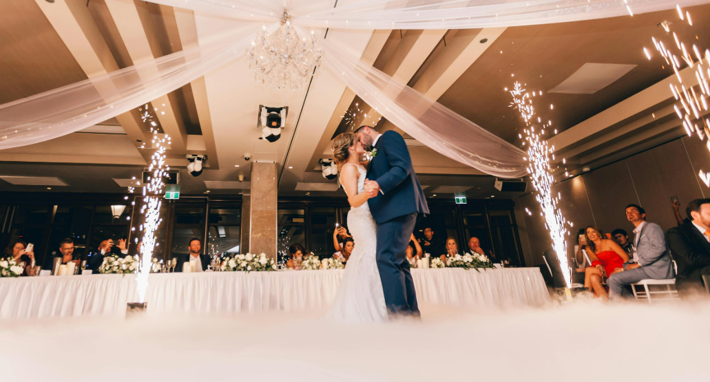 Cocosbride Bride in mermaid wedding dress and groom in suit sharing a romantic moment at their wedding
