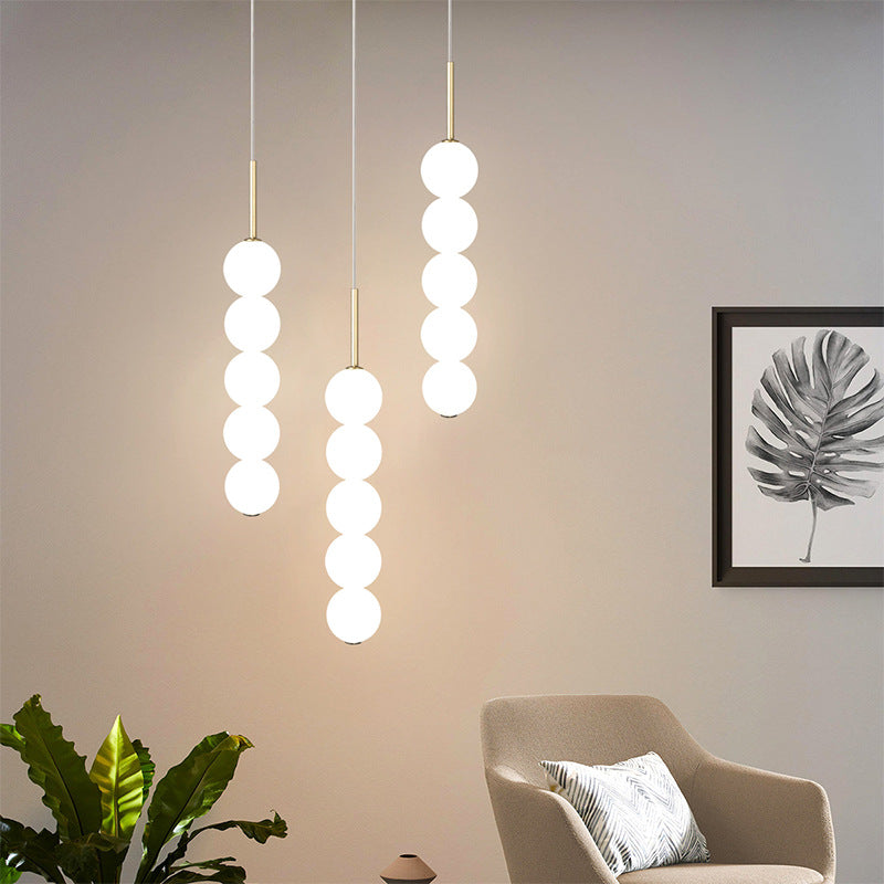 Modern pendant lights with white globes, ideal for bedroom or restaurant