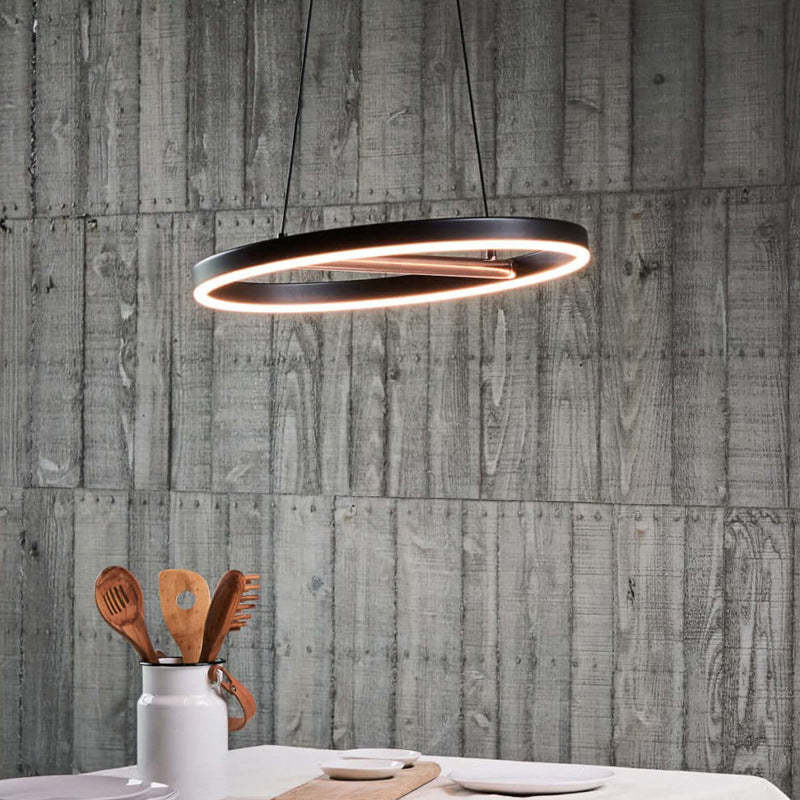 Oval LED pendant light above a dining table, Lassola lighting