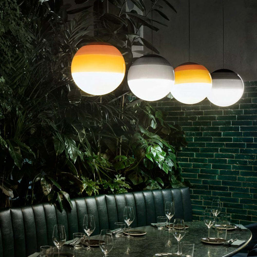 Hailie glass pendant lights over restaurant table.
