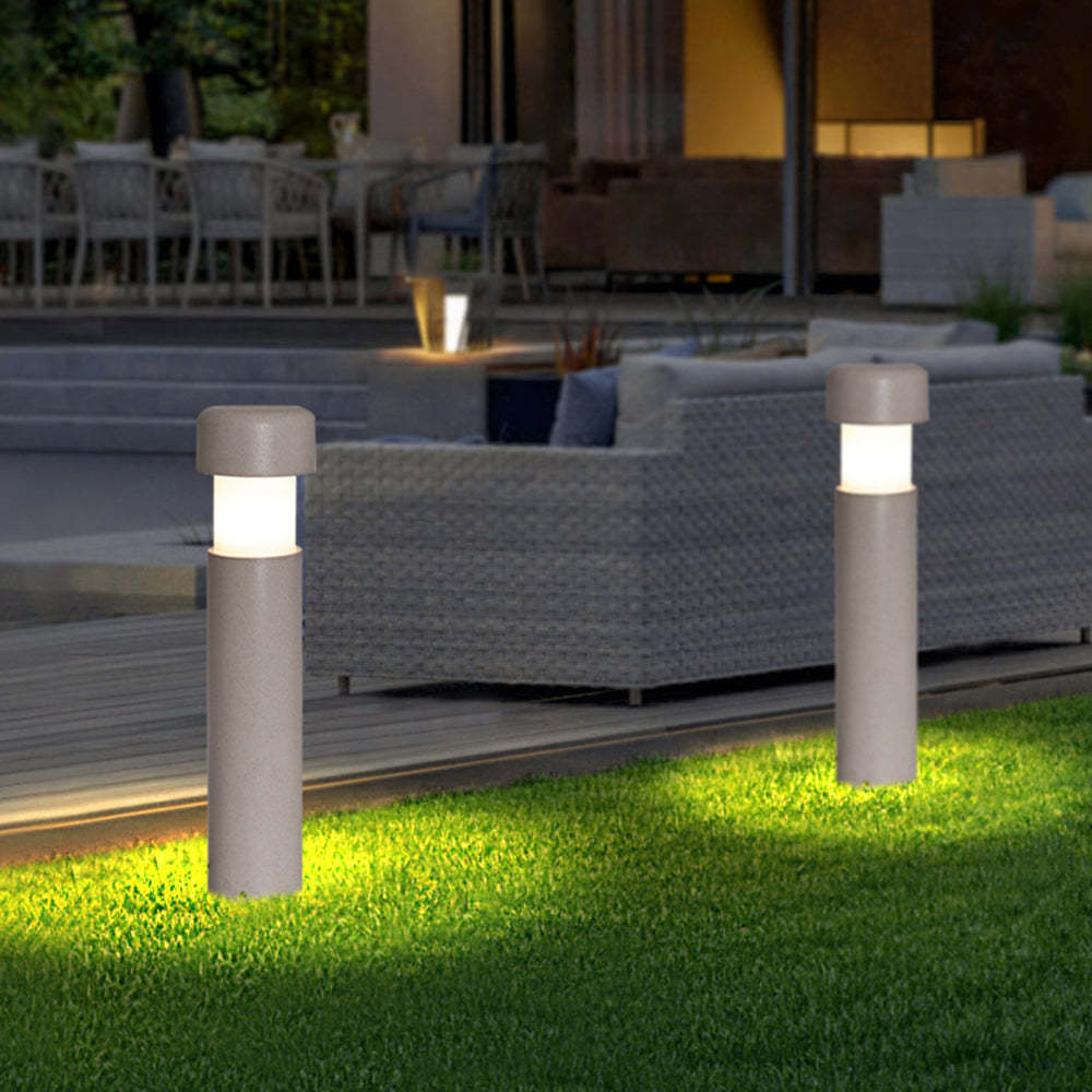 Modern gray outdoor path lights illuminating a garden at night