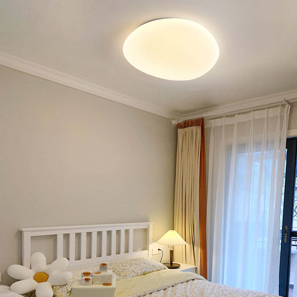 Modern Quinn pebble ceiling light illuminating bedroom