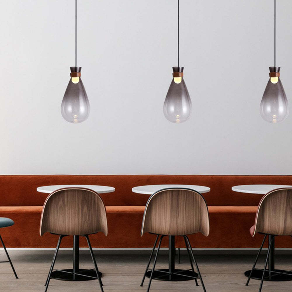 Smoke gray glass pendant lights in minimalist dining area