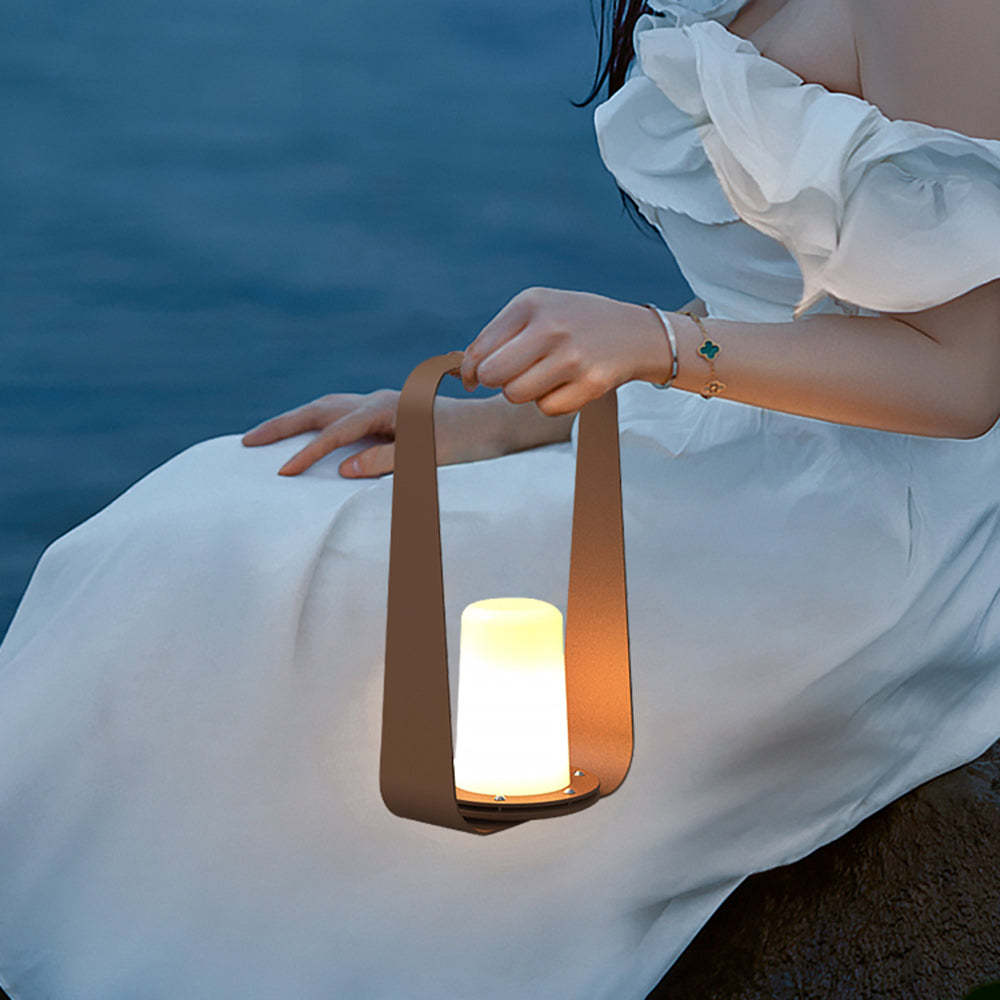 Woman holding Orr portable outdoor lamp, warm light