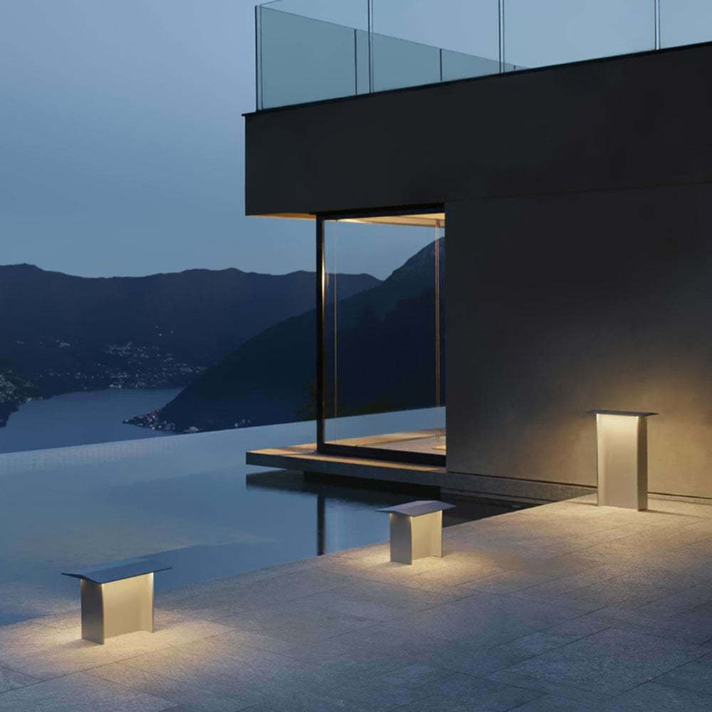 Modern outdoor path lights illuminating a contemporary patio at dusk