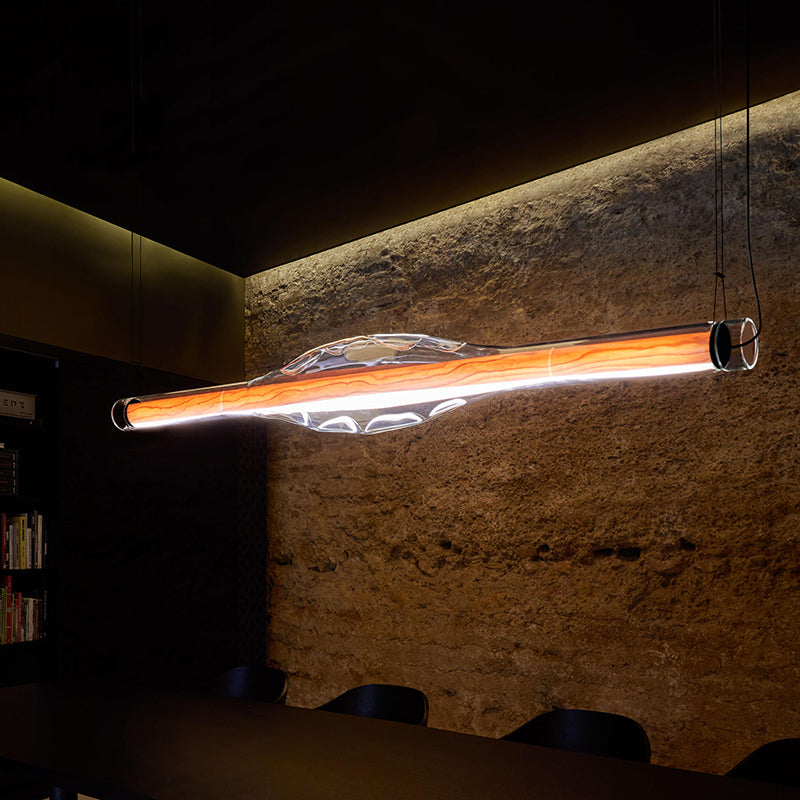 Edge Modern Tubular Pendant Light illuminating a dining room, modern design.