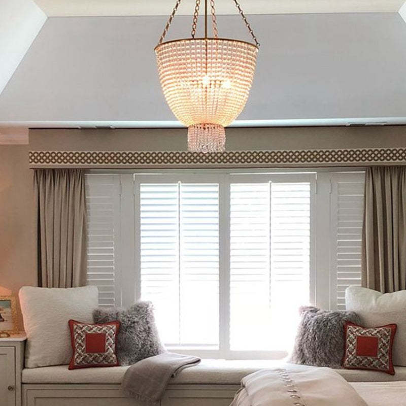Alessio Chandelier above window seat in bedroom. Modern LED lighting.