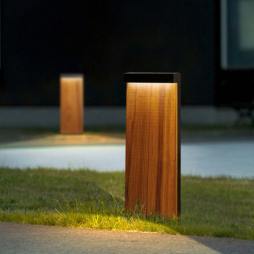 Outdoor wood path light illuminating a garden at night