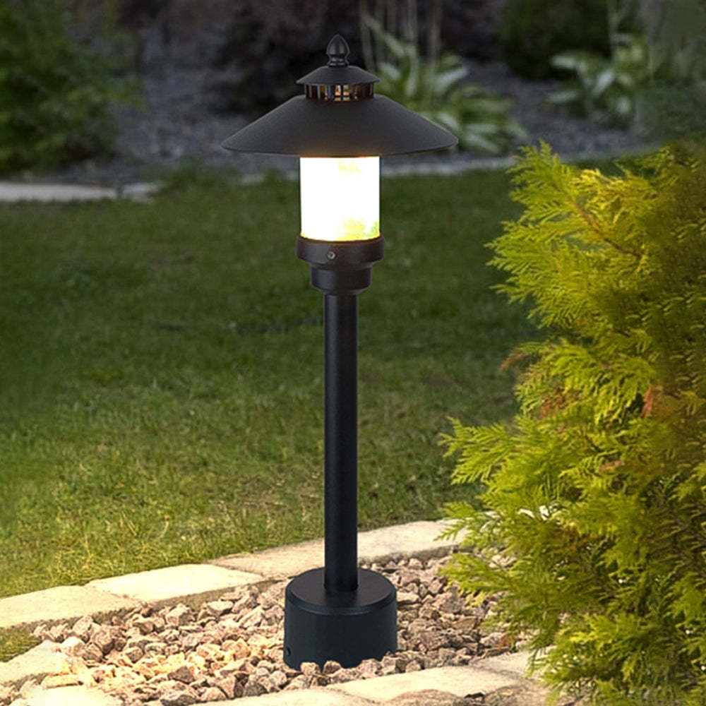 Outdoor Carins path light in a garden with green plants