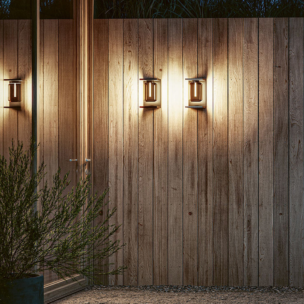 Orr metal & glass solar wall lamps illuminate wood fence.