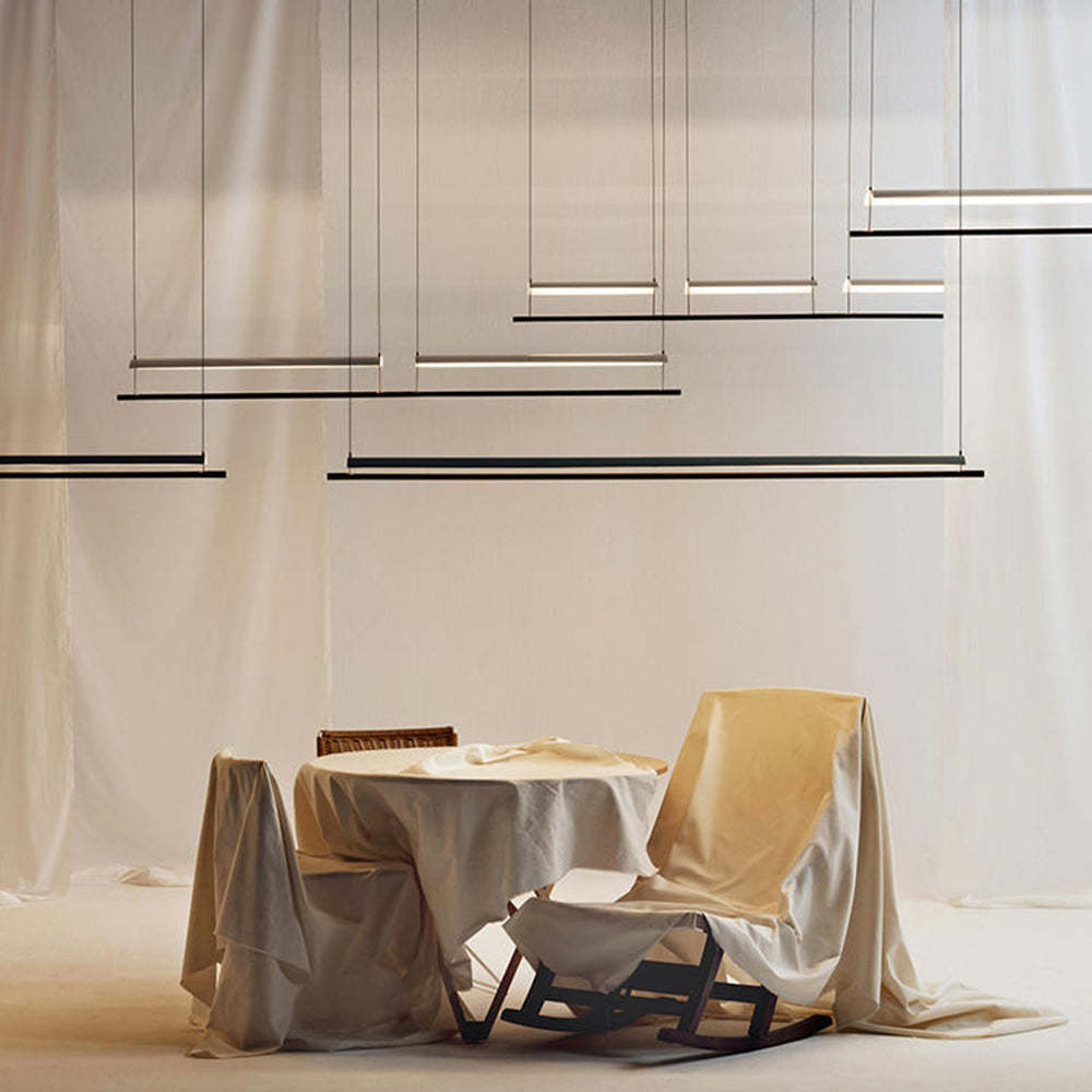 Modern linear pendant lighting over dining set