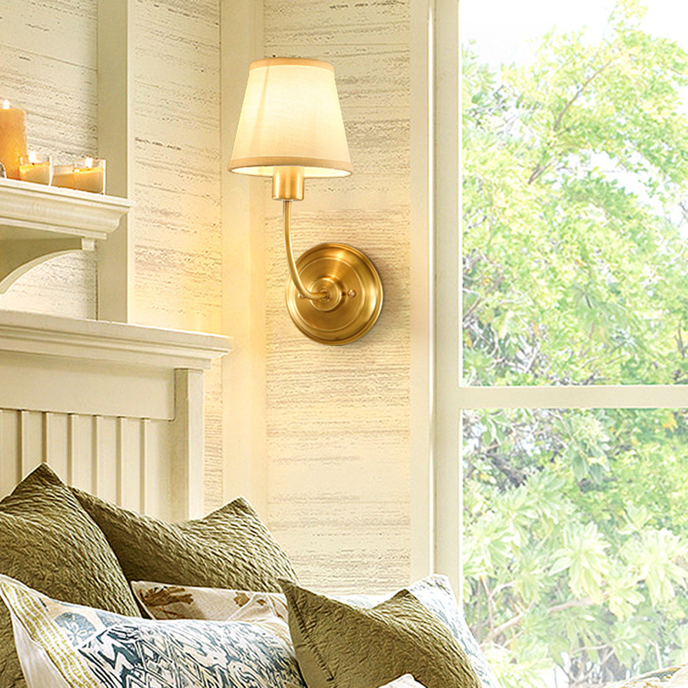 Rustic gold wall lamp lighting a bedroom, Alessio vintage style