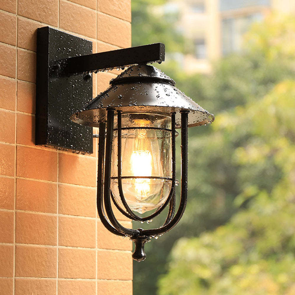 Black Alessio lantern wall lamp on brick. Vintage outdoor lighting.