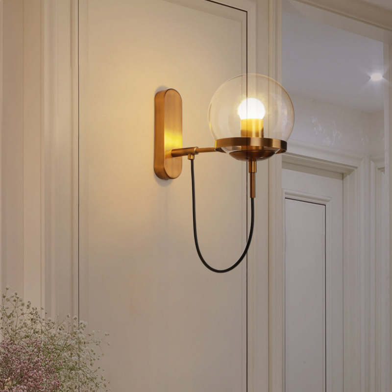 Alessio bronze wall lamp with glass globe shade on wall