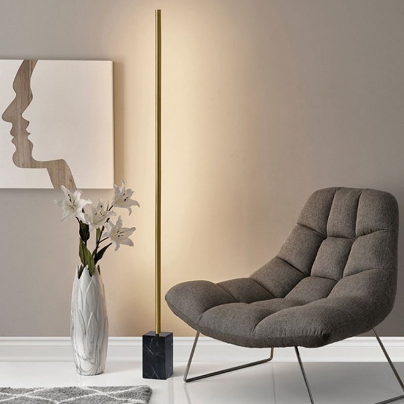 Modern floor lamp with marble base near armchair