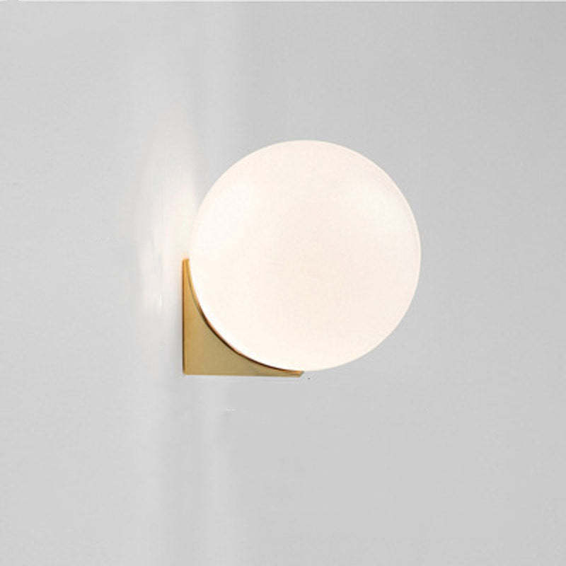 Valentina Wall Lamp: Gold metal base with a ball-shaped glass shade