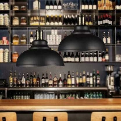 Black Cooley pendant lights over bar. Industrial metal dome lighting.