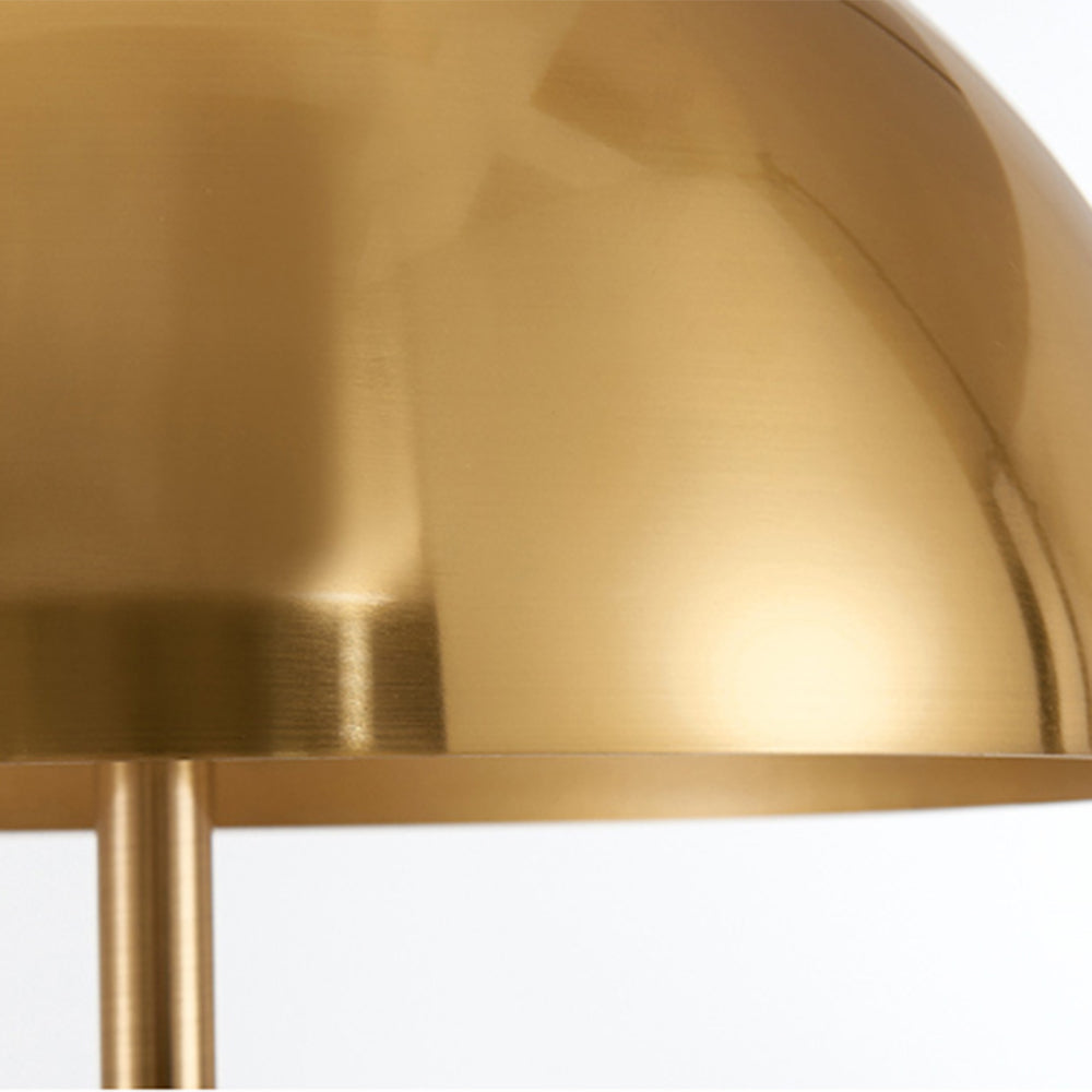 Gold shade of metal tripod floor lamp
