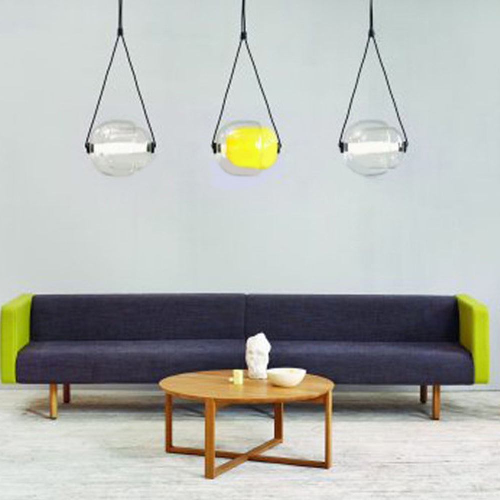 Modern glass pendant lights above living room setting.