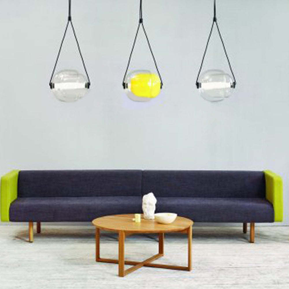 Modern glass pendant lights above living room setting.