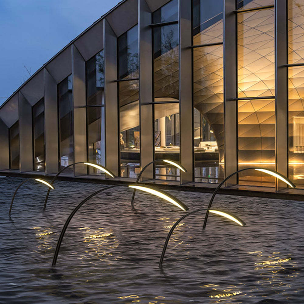 Minimalist arc poolside lights illuminating water feature