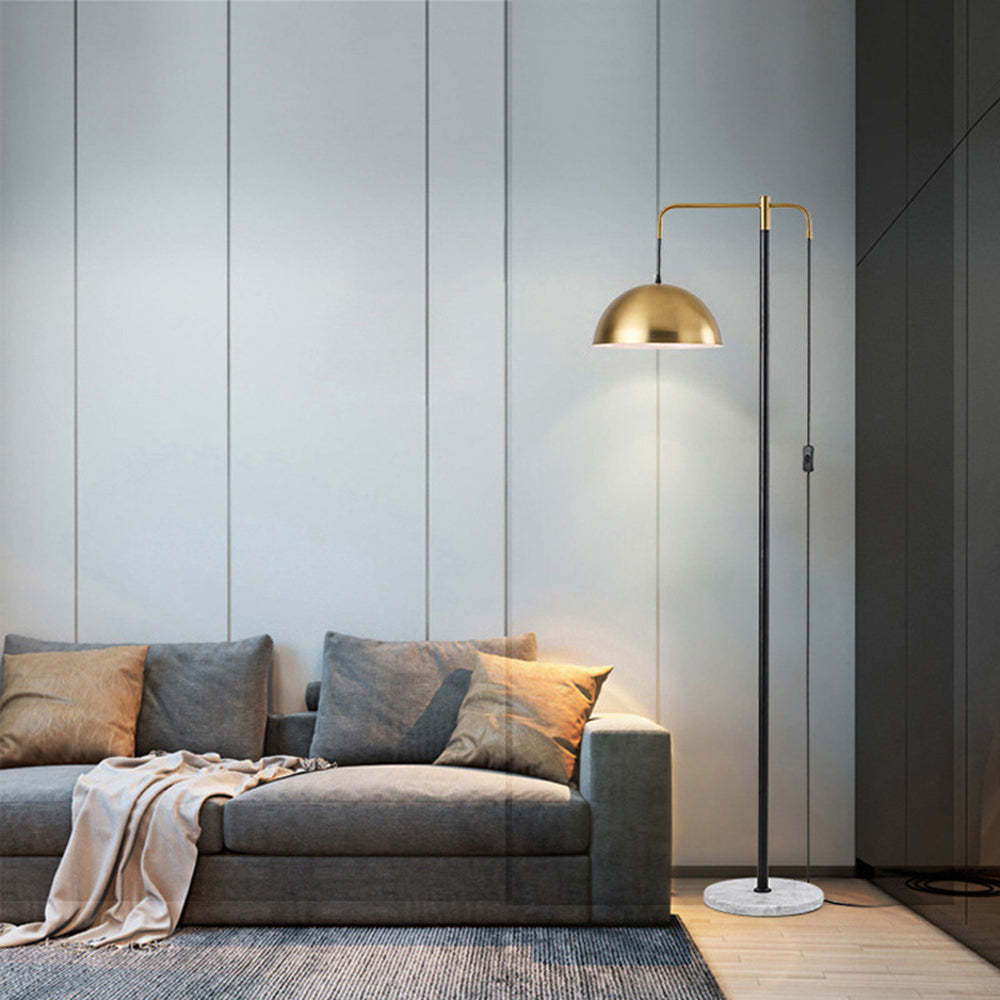 Carins floor lamp with gold shade and marble base in living room.