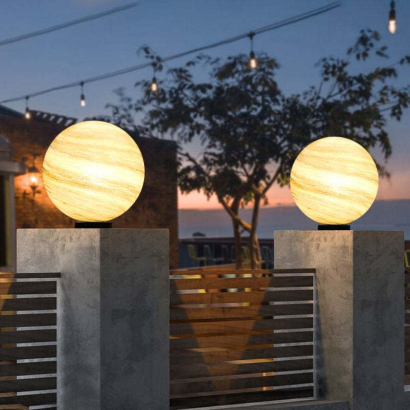 Elif Moon Globe Lights on fence posts at dusk