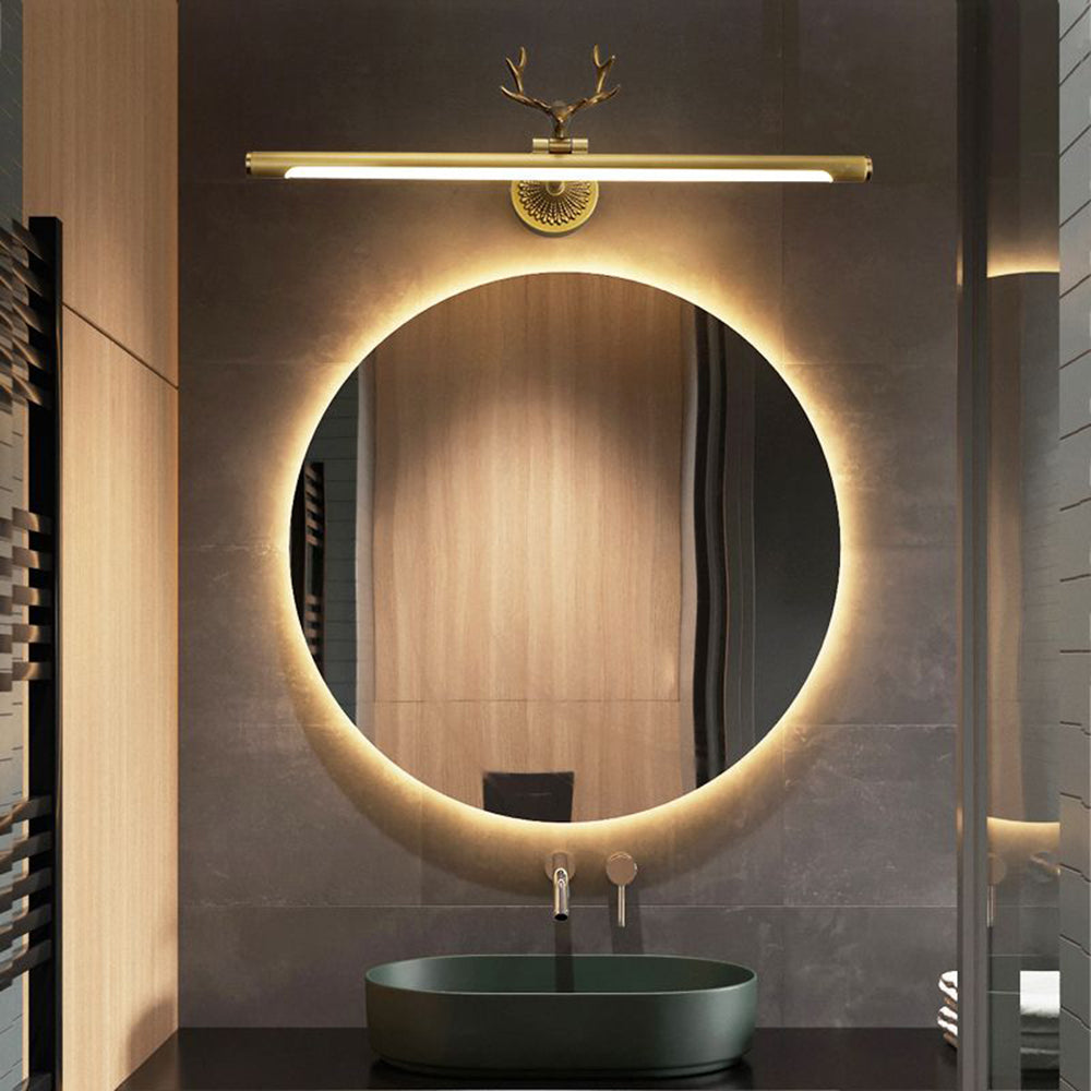 Modern brass staghorn vanity light above lighted mirror.