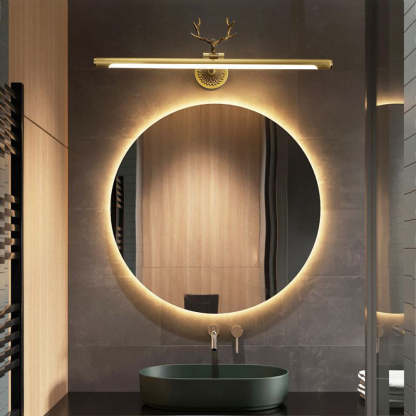 Modern brass staghorn vanity light above lighted mirror.