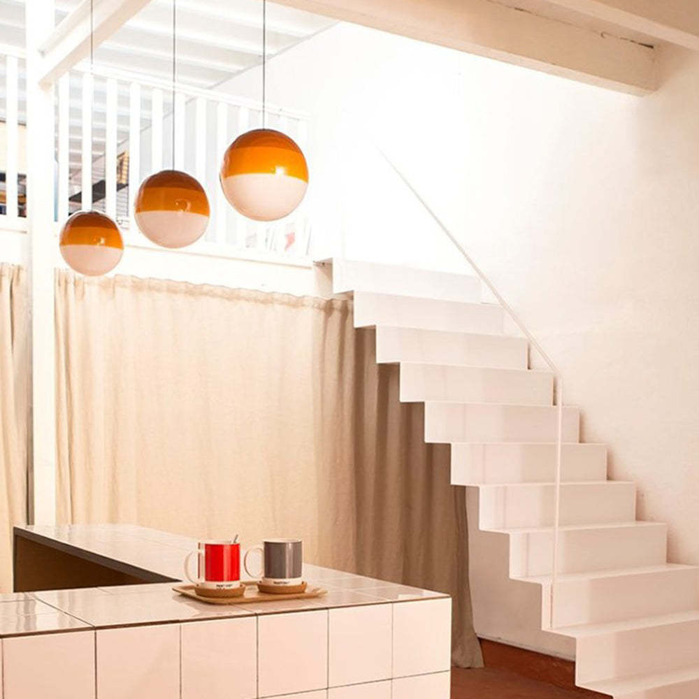 Orange glass bubble pendant lights near white stairs.