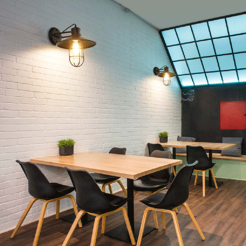 Alessio Wall Lamp illuminates a cafe setting.