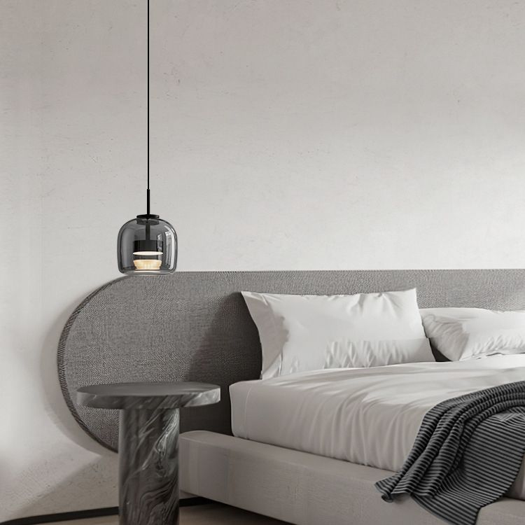 Hailie glass pendant light over bedside table.