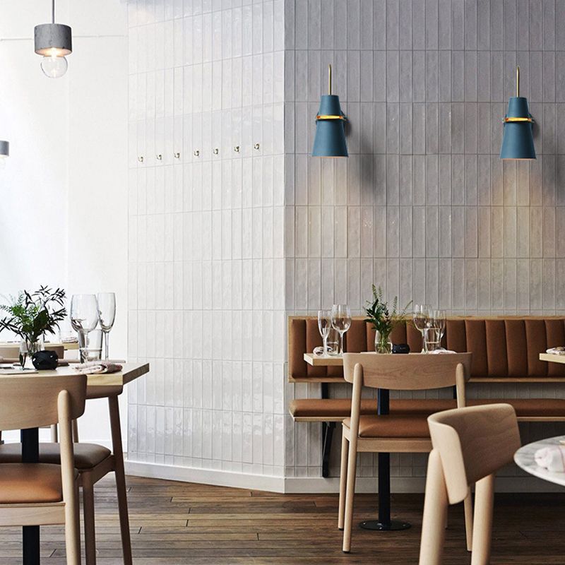 Blue Morandi metal wall lamps illuminate restaurant space.