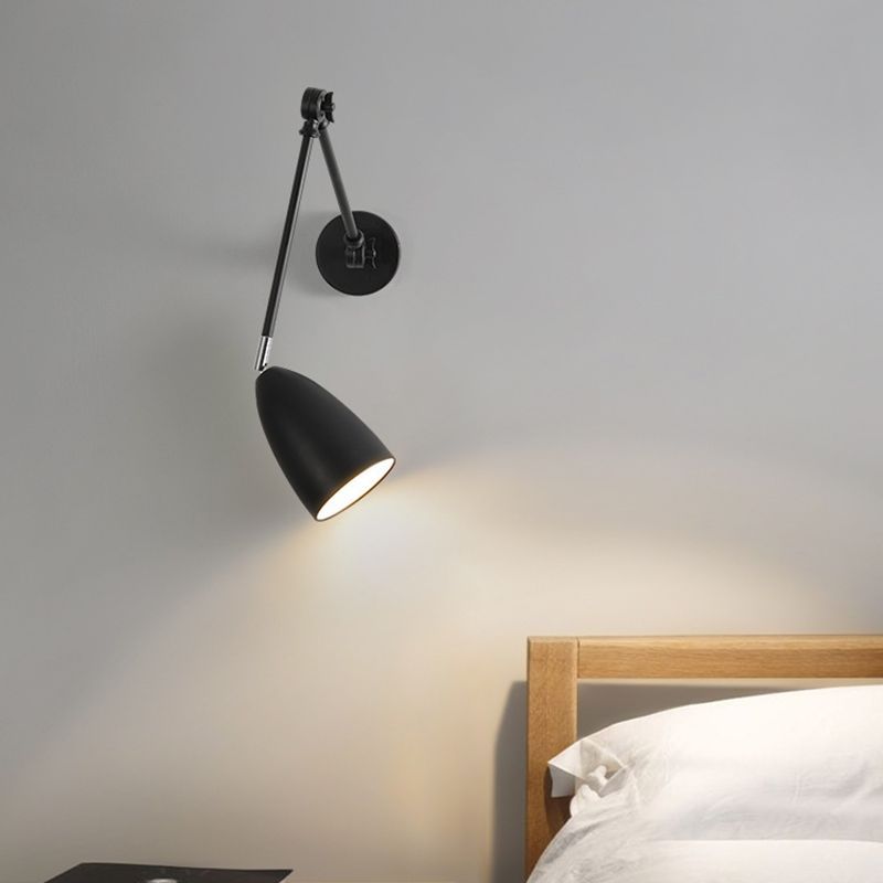 Black Brady Adjustable Wall Lamp shining light on bedroom