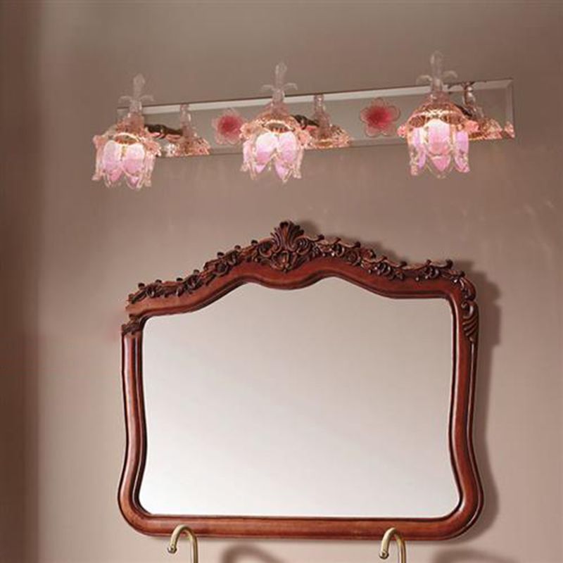 Pink Félicie flower wall lamp lighting a bathroom mirror.
