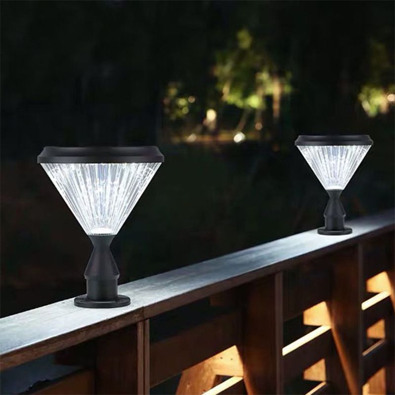 Riley Outdoor Pillar Lights on a wooden railing, emitting bright white light.