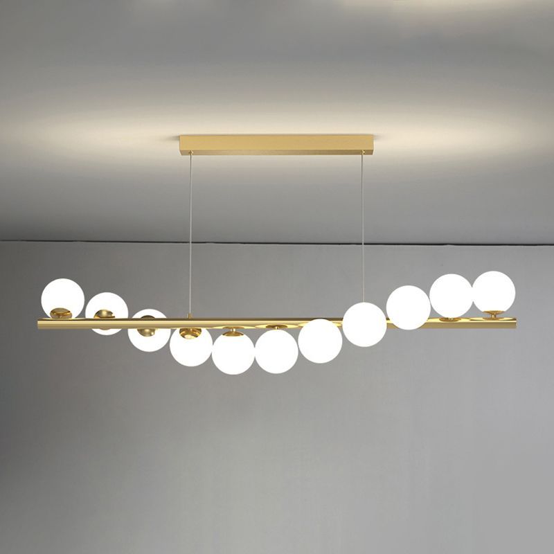 Gold linear pendant light with white globe lights