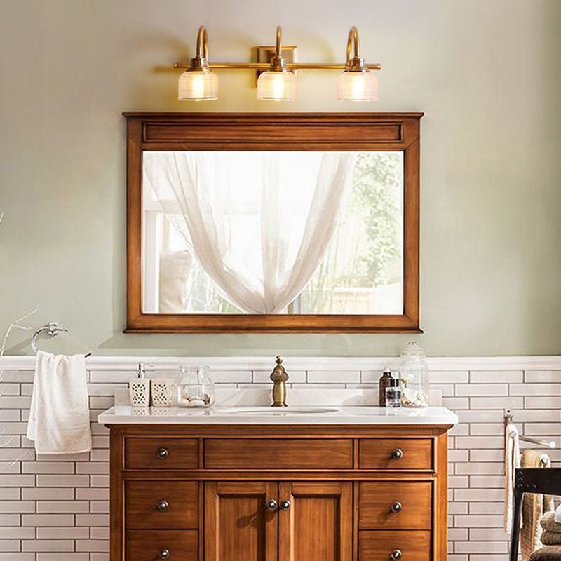 Lottie Prismatic vanity lamp in bathroom setting, glass and brass fixture
